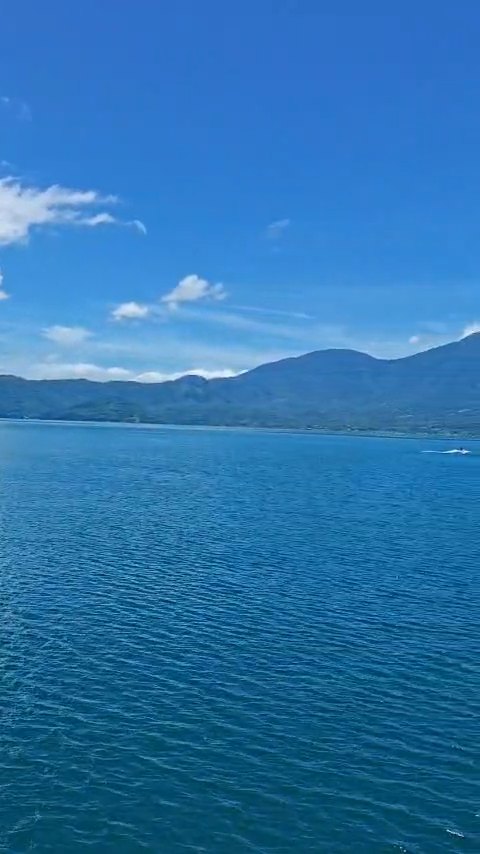 Aguas abiertas del Lago de Coatepeque con una lancha a lo lejos